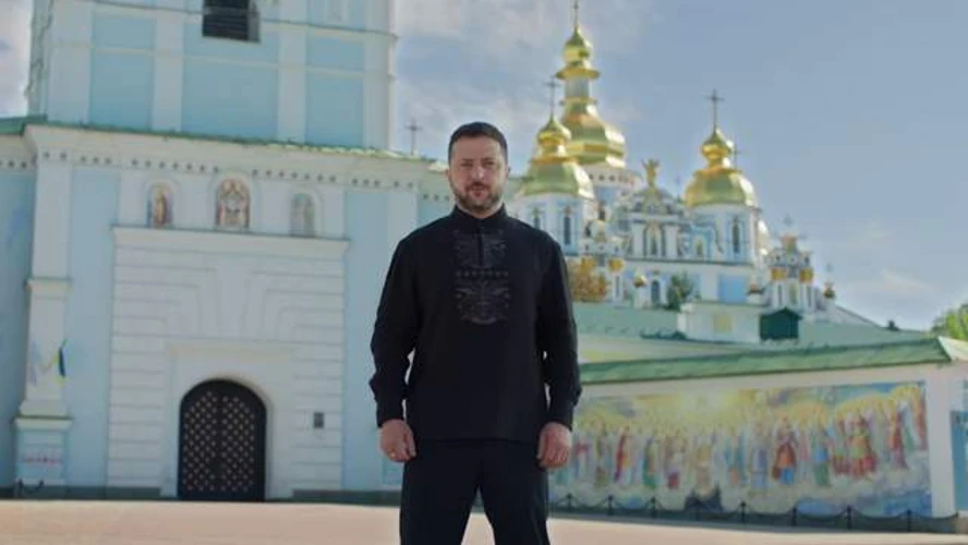 Володимир Зеленський у чорній вишиванці з довгими рукавами та сірою вишивкою з геометричним орнаментом на тлі Михайлівського